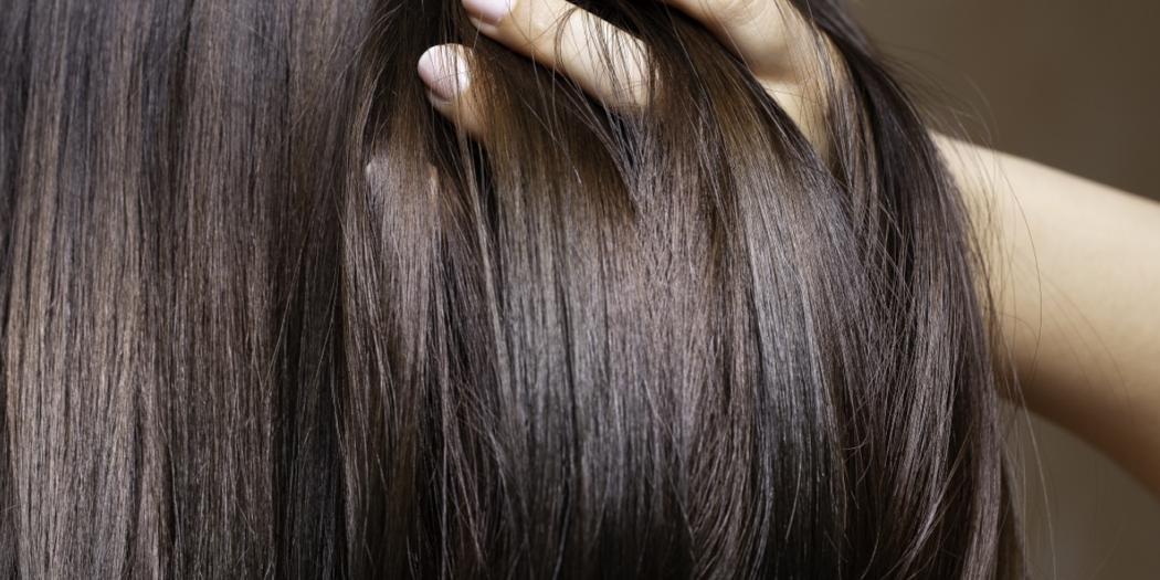 Kobieta przeczesująca dłonią ciemne włosy
