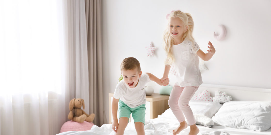 dzieci skaczące po łóżku