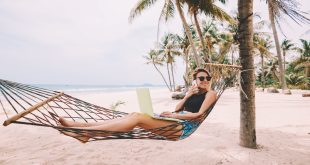 dziewczyna ze smartfonem i laptopem na egzotycznej plaży