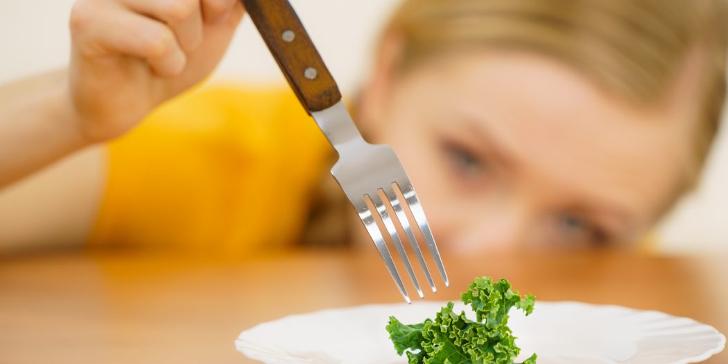 kobieta z liściem jarmużu na talerzu