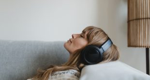 kobieta słuchająca muzyki na kanapie