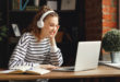 kobieta w słuchawkach na uszach przed komputerem
