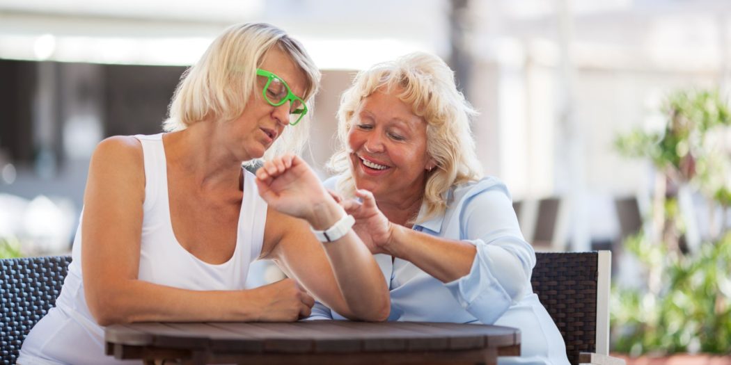 dwie dojrzałe kobiety sprawdzające godzinę na zegarku jednej z nich