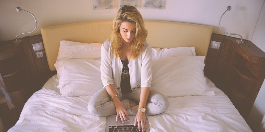 kobieta w łóżku robiąca zakupy przez internet