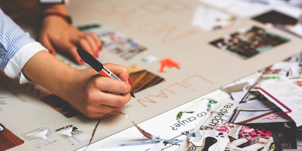 kobieta projektująca na papierze materiały graficzne