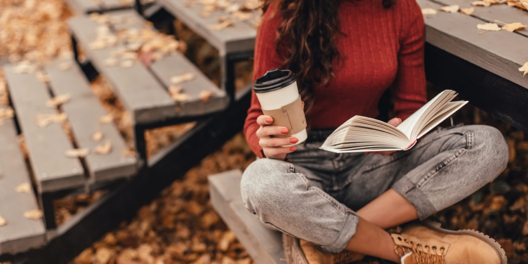 piękna kobieta czytająca jesienią ksiązkę na zewnątrz