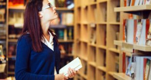 młoda kobieta szukająca książek w księgarni