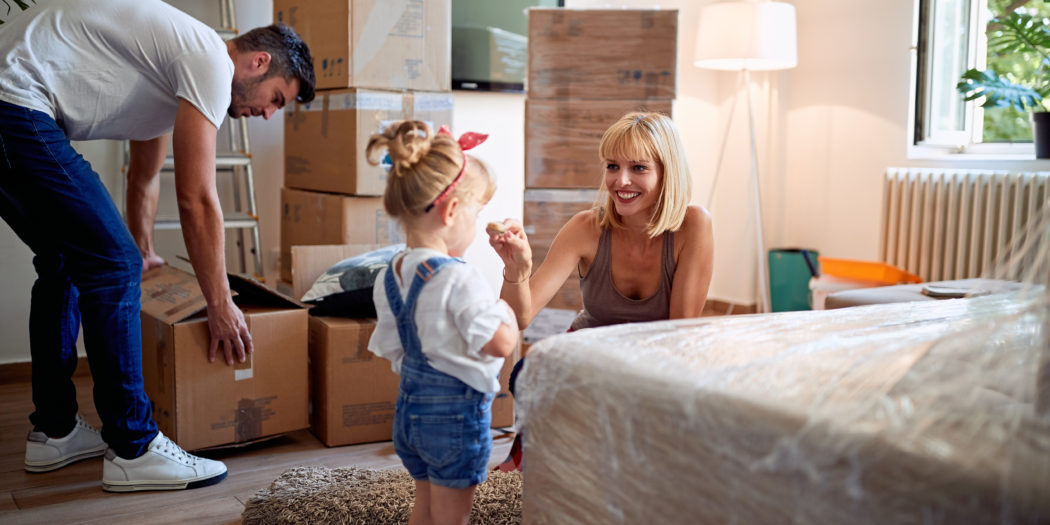 szczęśliwa rodzina zajmująca się pakowaniem rzeczy w sypialni do kartonów