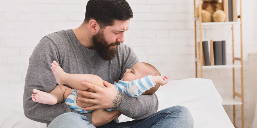 dziecko płaczące na rękach u ojca