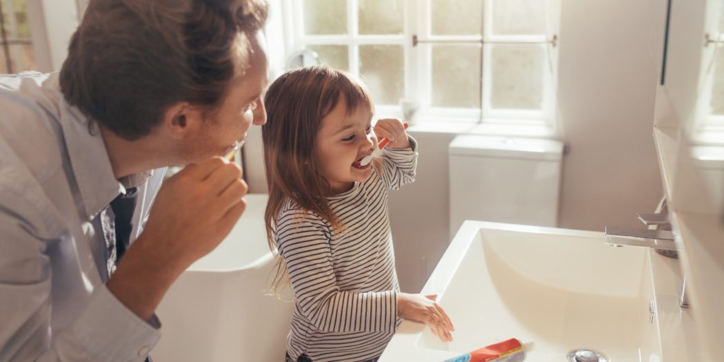dziewczynka myjąca zęby z tatą