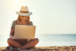 kobieta na plaży z laptopem