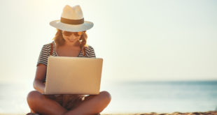 kobieta na plaży z laptopem