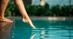 zbliżenie na kobiece stopy dotykające wody w basenie
