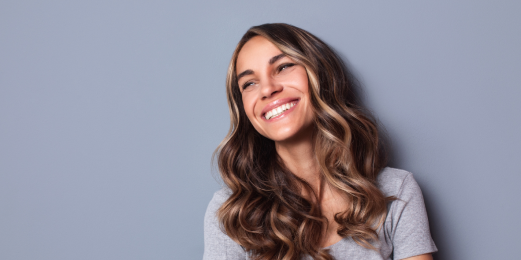 Piękna uśmiechająca się kobieta na szarym tle