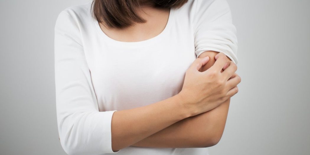 Kobieta drapiąca się w ramię